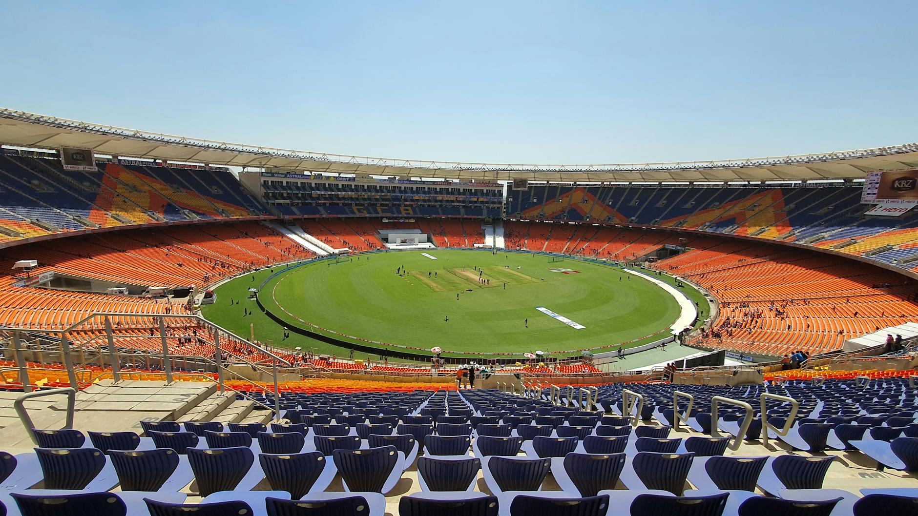 Wide shot of graffiti-adorned Narendra Modi Stadium, highlighting its expansive seating and cricket field. - 11 Dead in Stampede Outside India Cricket Stadium