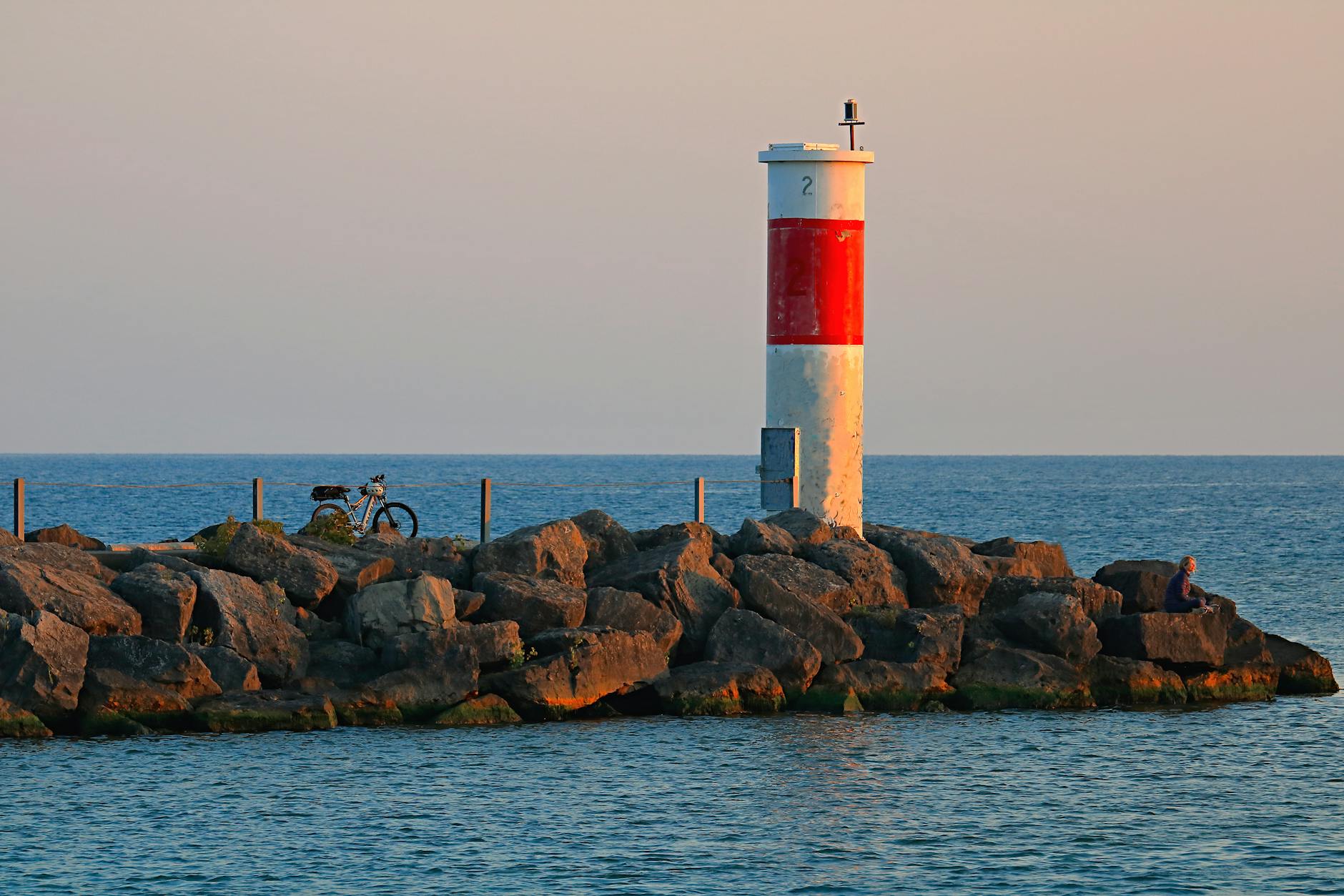 Andrew Cuomo Wins First NYC Democratic Mayoral Primary Debate 3 A calming scene of sunrise at Webster's lighthouse with rocks and a bicycle. - Andrew Cuomo Wins First NYC Democratic Mayoral Primary Debate