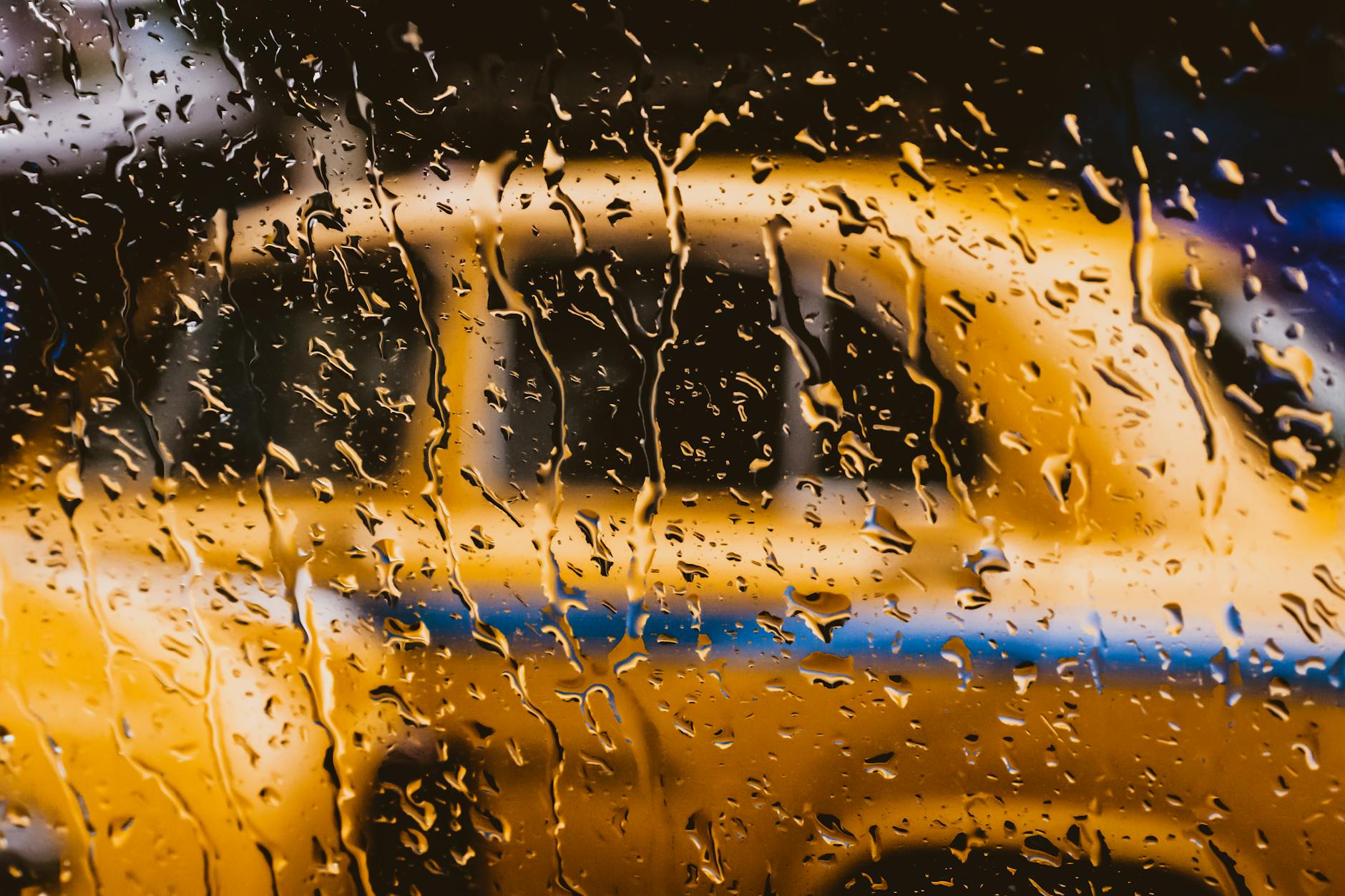 Can the Monsoon Be Urban India's Hero Again? 1 Blurred view of a yellow taxi through a rain-soaked window in Kolkata, India. - Can the Monsoon Be Urban India's Hero Again?