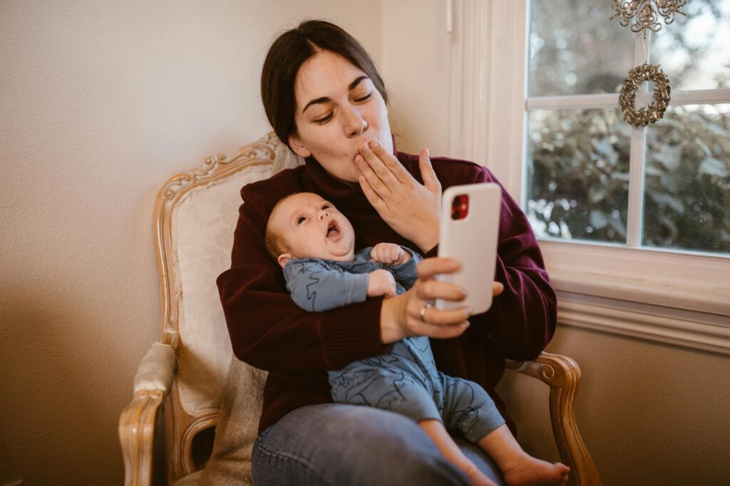 A mother and baby enjoy a video call indoors, capturing a tender moment of connection and warmth.