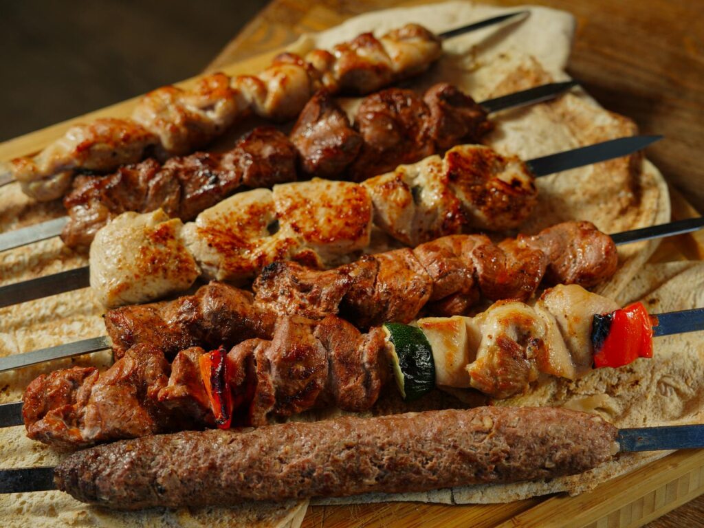 A variety of grilled meat skewers served on flatbread, showcasing delicious kebabs. - Easy Chicken Mince Kebab Recipe – Spicy & Juicy Patties