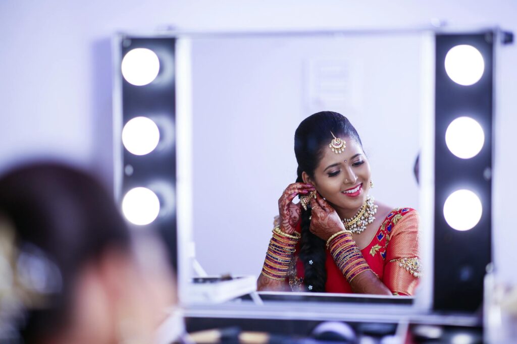 Captivating Indian bride adorned in traditional attire, smiling at her reflection while preparing for a wedding ceremony. - Elon Musk's Starlink Gets Satcom Licence in India