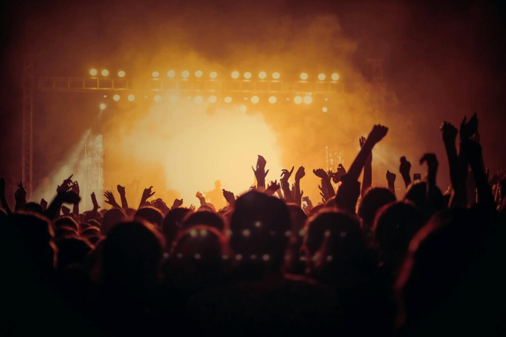 Energetic music concert with a vibrant crowd cheering under bright stage lights. - Huawei Band 10 First Impressions: Features & Performance