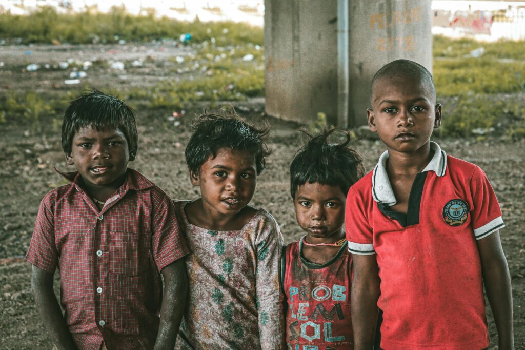 Group of four children posing under an urban bridge with expressions of resilience. - L&T Raises ₹500cr via India's 1st Listed ESG Bond with HSBC