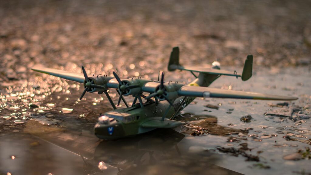 Model plane resting in mud, capturing wartime nostalgia and detail.
