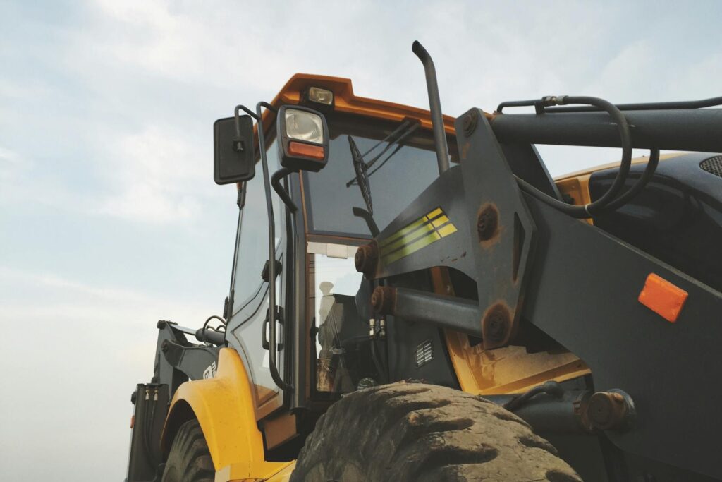 Detailed view of a yellow excavator against a clear sky at a construction site. - Top 5 Precision Engineering Stocks in India for 2024